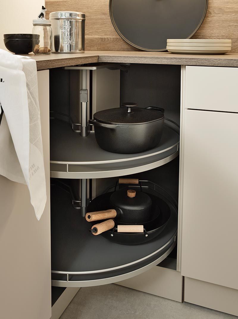 Karussell-Eckschrank mit schwarzen Töpfen und Pfannen auf zwei Ebenen.