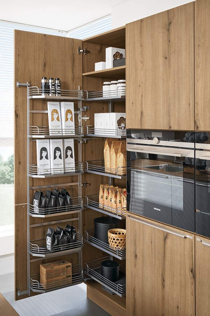 Geöffneter Hochschrank mit Türregalen und Innenauszügen voller Lebensmittelpackungen.