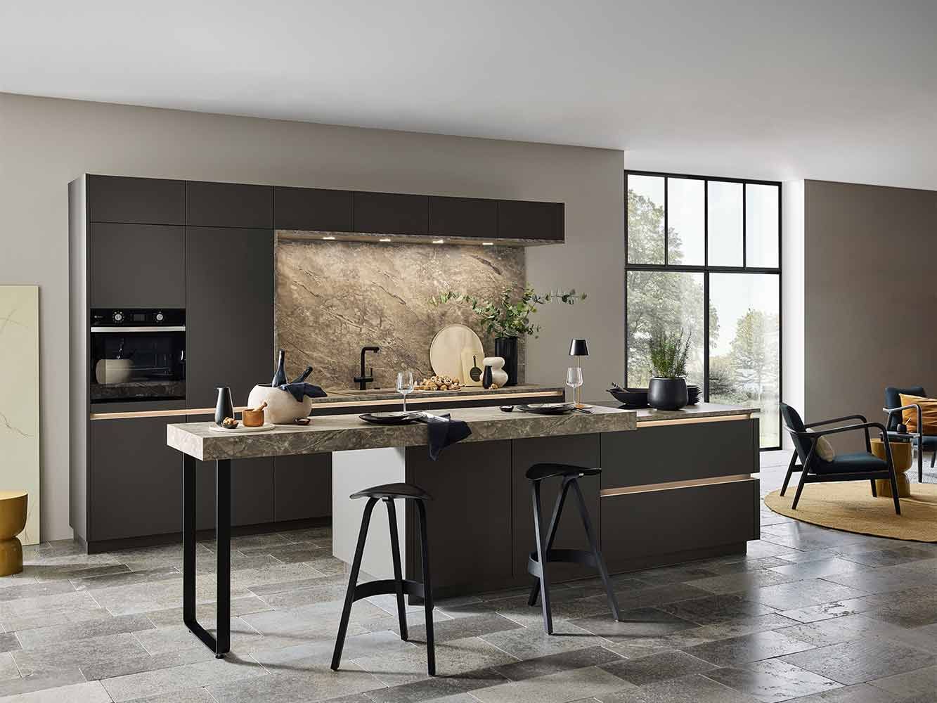 Dunkle grifflose Küche mit massiver Steinarbeitsplatte, Kochinsel und Barhockern.